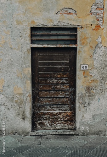 old brown wooden door with wall, featuring weathered textures. 