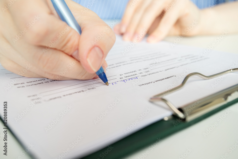 Construction contract, hand fills out a document, business negotiation on project design, estate agent facilitating property deal Construction contract, hand fills out a document, business negotiation on project design, estate agent facilitating property deal