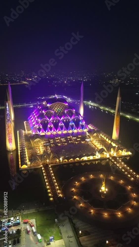 Drone view Al-Jabbar mosque in the night. Established Aerial Shot of Al-Jabbar Great Mosque and Rural Landscape photo