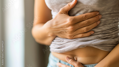 A young woman holding her stomach, abdominal pain, endometriosis, irritable bowel syndrome (IBS), ulcerative colitis, ectopic pregnancy, ovarian cysts, pelvic inflammatory disease (PID), gastro photo
