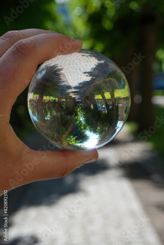Cropped hand holding a crystal ball outdoors