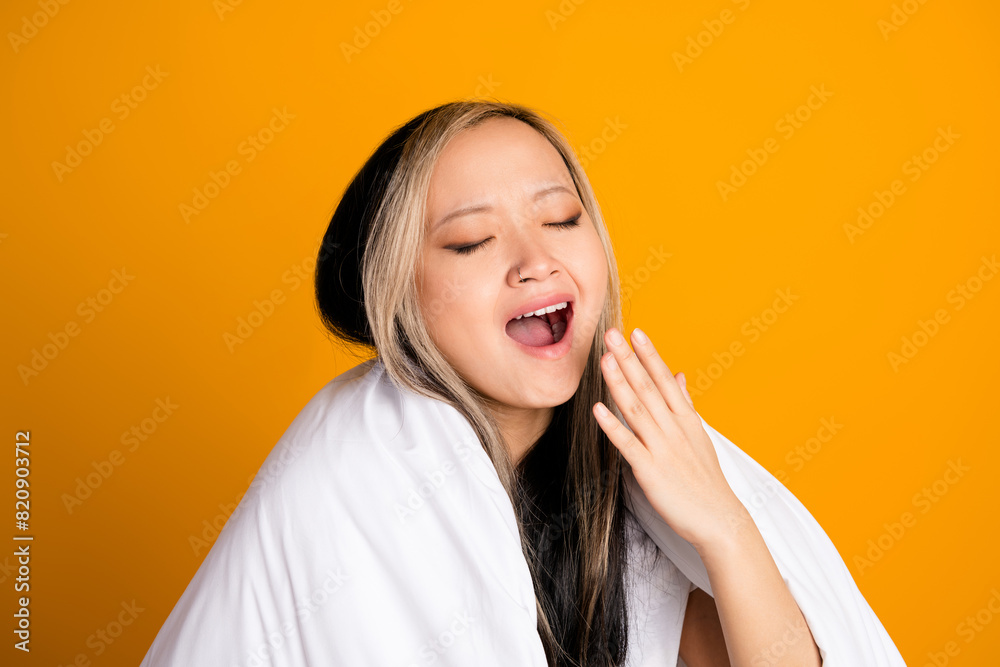 Photo of adorable cute woman wrapped warm blanket cover mouth yawn isolated on yellow color background Photo of adorable cute woman wrapped warm blanket cover mouth yawn isolated on yellow color background