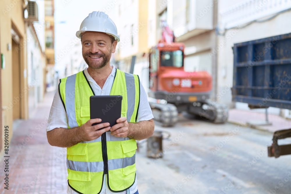 Middle age man architect using touchpad at street Middle age man architect using touchpad at street