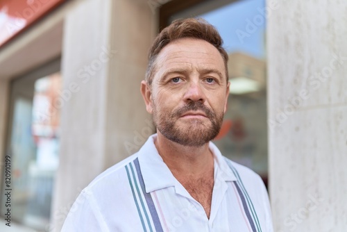 Middle age man standing with serious expression at street