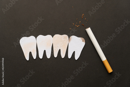 Cigarettes or tobacco with tooth shape on black background. Teeth problems caused by smoking include staining, gum disease and cavities. World no tobacco day concept template.