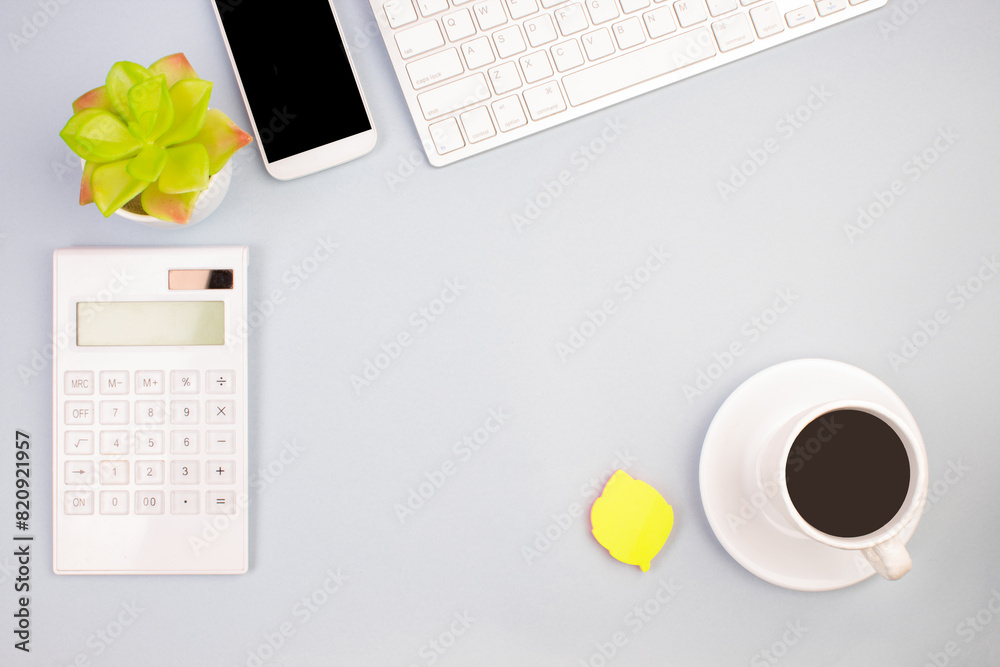 Tablet, calculator, phone, pen and a cup of coffee, lot of things on a light background. Top view with copy space. Tablet, calculator, phone, pen and a cup of coffee, lot of things on a light background. Top view with copy space.