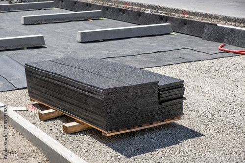 Rubberized road surface for sound insulation in tramway track repair is laid out on an industrial pallet, ready for installation. Modern building materials.