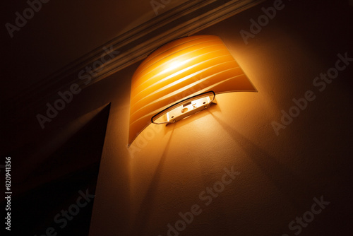 Warm Yellow Sconce Light Fixture on Wall Inside Cozy Home During Evening