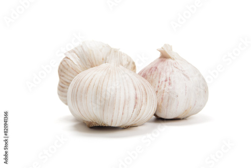 Three Whole Garlic Bulbs With Cloves on a White Background in Bright Daylight