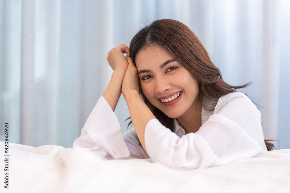 Portrait of smiling cheerful beautiful pretty asian woman clean fresh healthy white skin posing smile in pajamas white clothes.Girl felling relax and enjoy time on the bed at home.asia beauty Portrait of smiling cheerful beautiful pretty asian woman clean fresh healthy white skin posing smile in pajamas white clothes.Girl felling relax and enjoy time on the bed at home.asia beauty