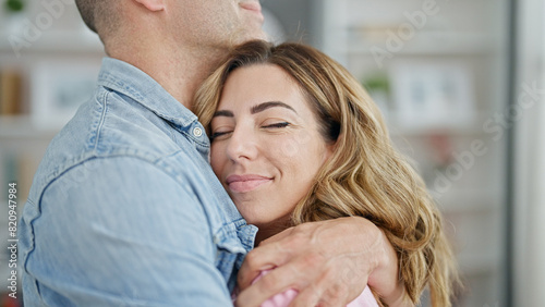 Man and woman couple hugging each other smiling at home