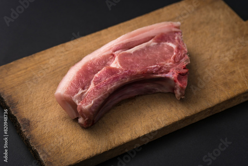 raw meat on wooden board and black background
