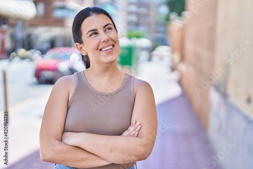 Young beautiful hispanic woman standing with arms crossed gesture at street Free Download Young beautiful hispanic woman standing with arms crossed gesture at street - GFXLoad