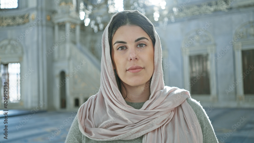 A young woman in a hijab stands in the ornate interior of a mosque, symbolizing faith and islamic culture. A young woman in a hijab stands in the ornate interior of a mosque, symbolizing faith and islamic culture.