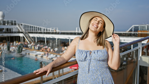Smiling woman in hat enjoys sunshine on cruise deck with ocean backdrop