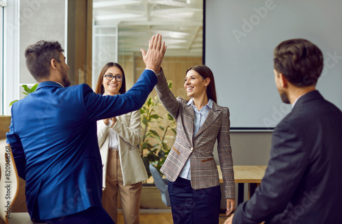 Business people high five happy team celebration or office greeting. Startup becoming radically productive, leadership and communications skills development, successful coaching or management photo