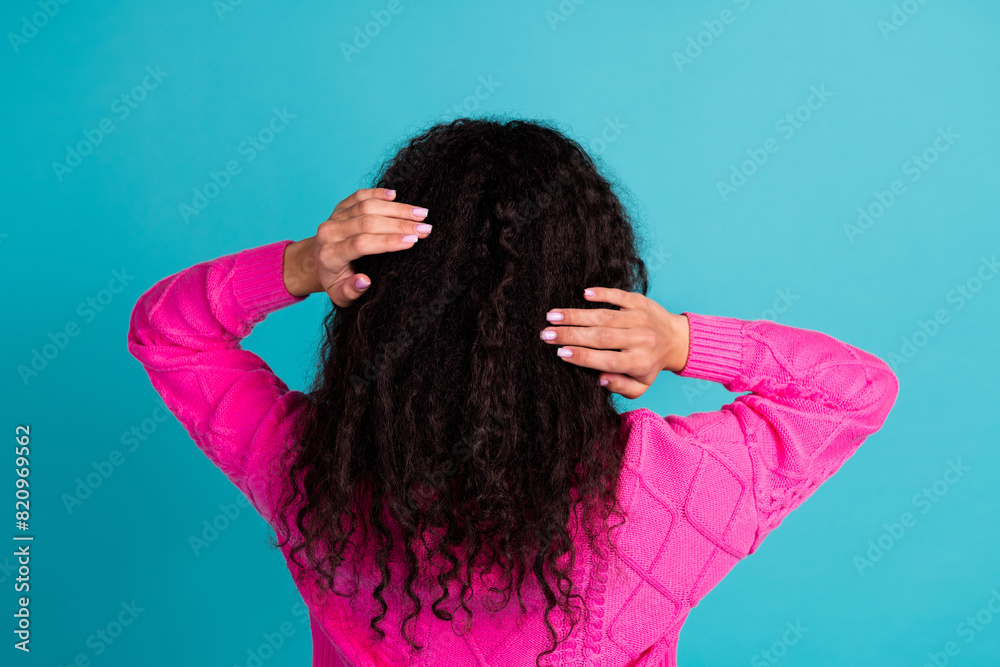 Rear photo of lovely young girl hands touch hair wear pink pullover isolated on teal color background Rear photo of lovely young girl hands touch hair wear pink pullover isolated on teal color background