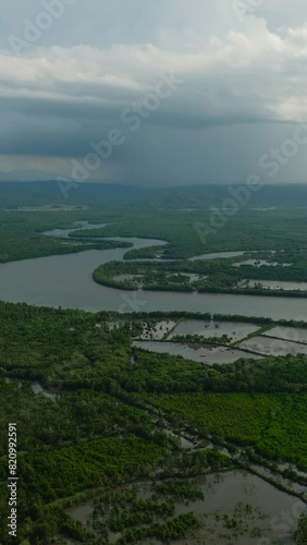 Drone view of river and aquaculture surrounded by tropical forest in Bislig, Surigao del Sur. Philippines. Vertical view. photo