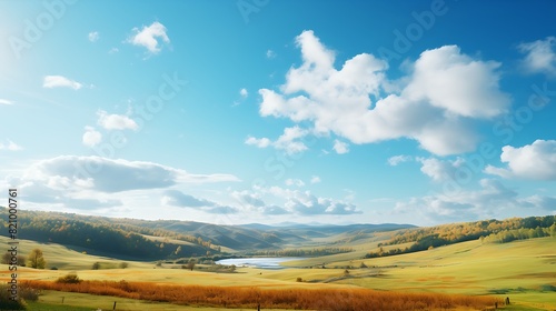 A picturesque countryside scene with rolling hills blanketed in colorful autumn foliage  under a clear blue sky with fluffy white clouds.