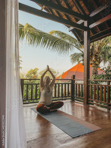 Middle aged woman practicing yoga on a balcony