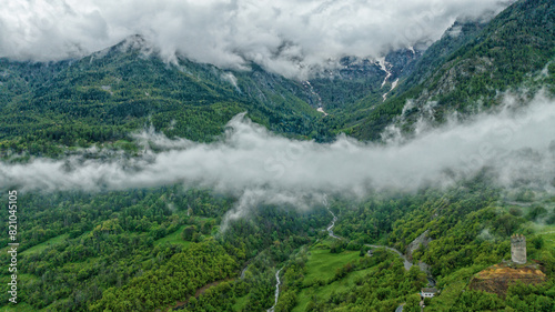 Mountain landscape, white clouds over green Alps mountains