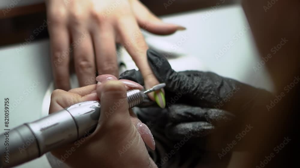 beauty master manicurist doing nails to a beautiful young girl in a beauty salon, female beauty and self-care, with her hands and fingers. Close up of handyman tools beauty master manicurist doing nails to a beautiful young girl in a beauty salon, female beauty and self-care, with her hands and fingers. Close up of handyman tools