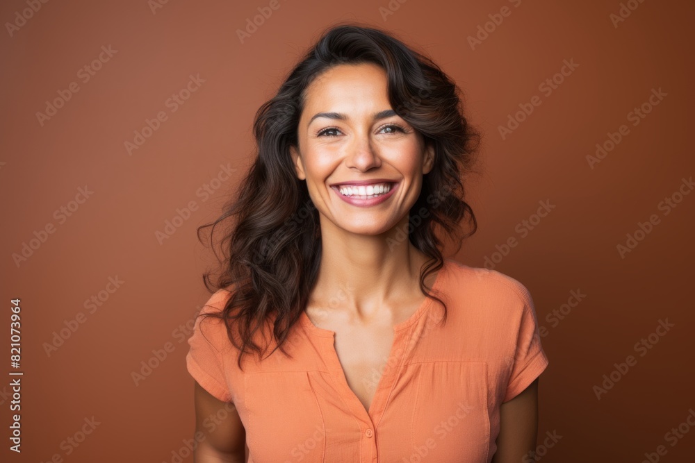 Portrait of a blissful indian woman in her 30s smiling at the camera over solid color backdrop Portrait of a blissful indian woman in her 30s smiling at the camera over solid color backdrop