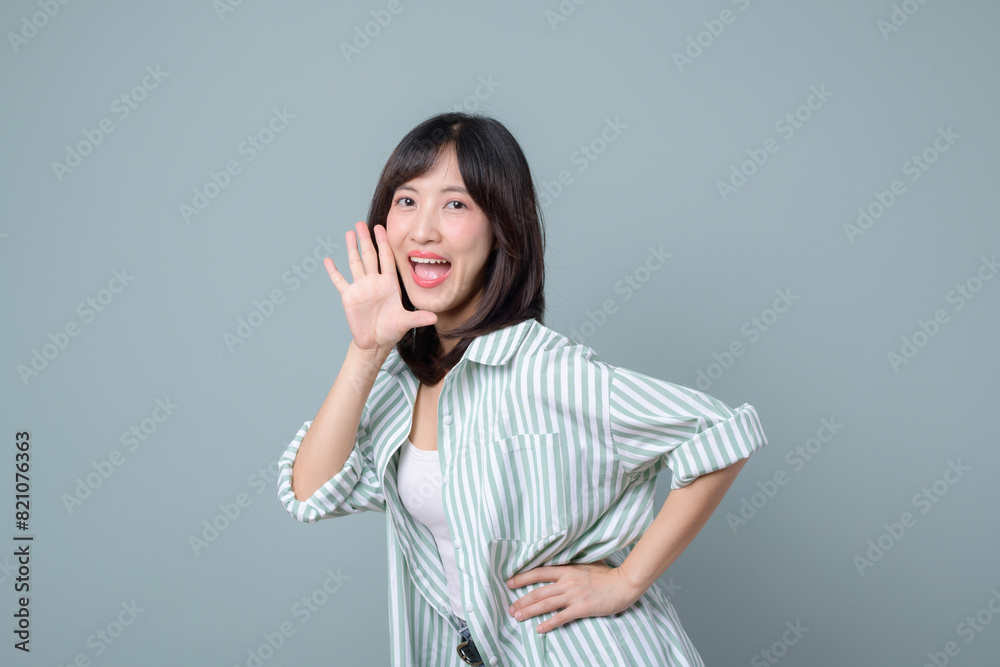 Profile view of a woman who loudly announces advertisements, news and information about discounts holding her hand near her mouth open. Lady exclaims near free space for text on green background. Profile view of a woman who loudly announces advertisements, news and information about discounts holding her hand near her mouth open. Lady exclaims near free space for text on green background.
