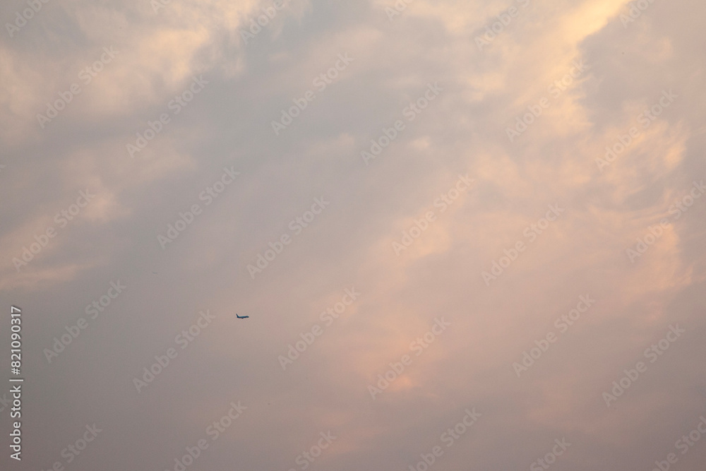 View of the flying airplane in the cloudy sky View of the flying airplane in the cloudy sky