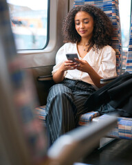 Businesswoman Commuting To Work On Train Sitting Checking Messages Or Social Media On Mobile Phone