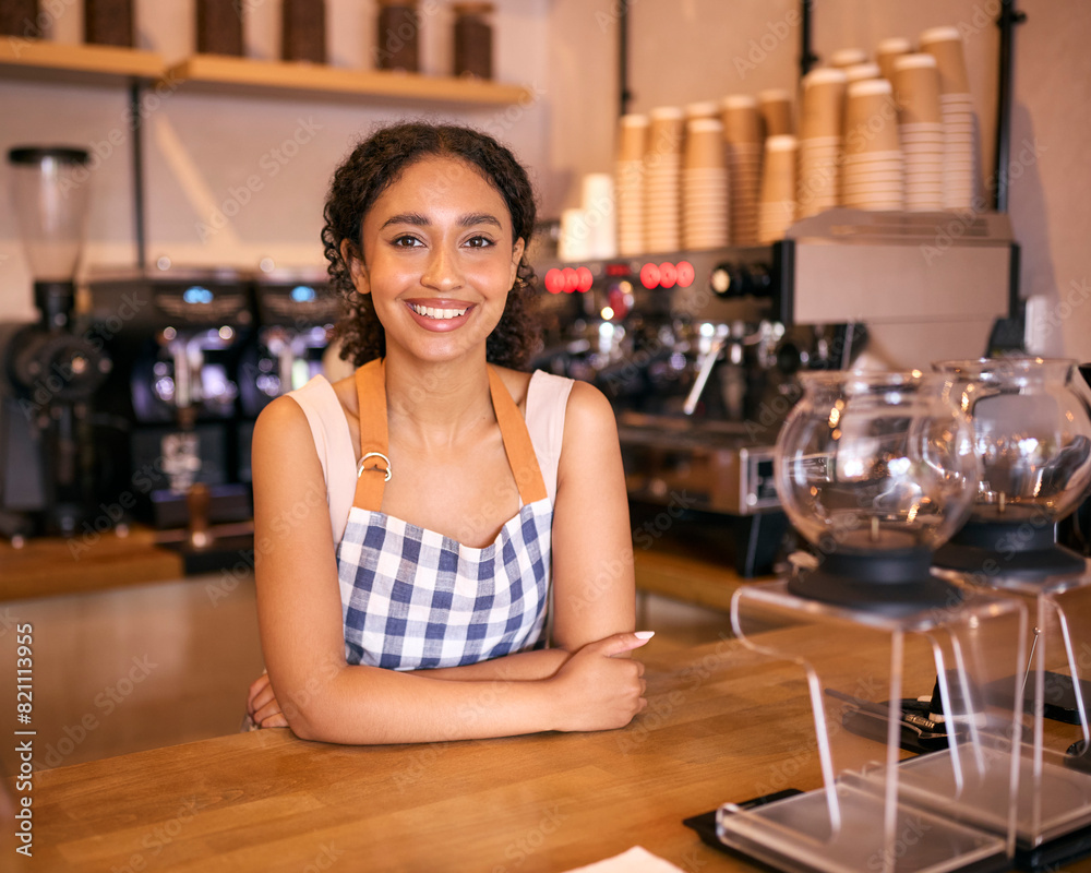 Portrait Of Confident Young Woman Wearing Apron Working In Coffee Shop Or Cafe