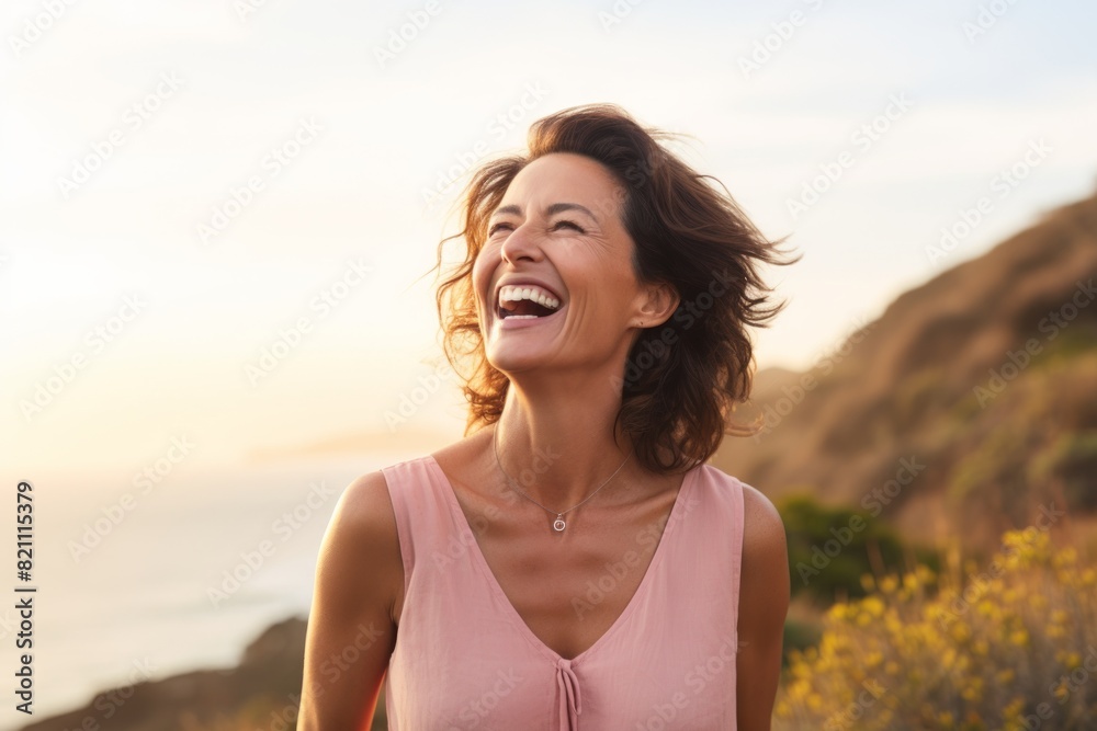 Portrait of a blissful woman in her 40s laughing isolated on solid pastel color wall Portrait of a blissful woman in her 40s laughing isolated on solid pastel color wall