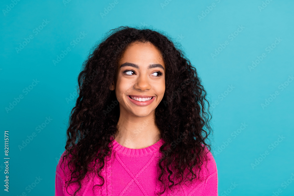 Photo of lovely young girl look empty space wear pink pullover isolated on teal color background Photo of lovely young girl look empty space wear pink pullover isolated on teal color background