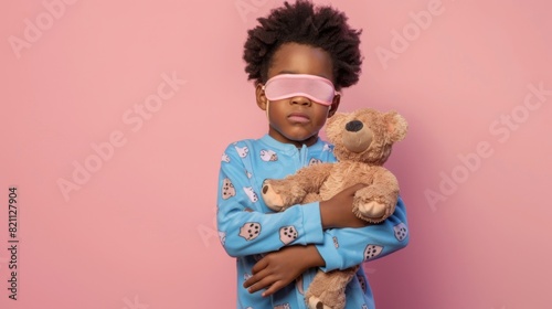 Child Holding Teddy Bear Sleepily photo