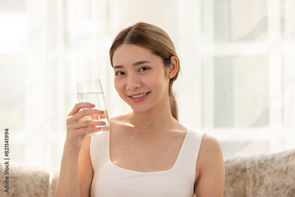 Young woman enjoying a refreshing glass of water at home. Bright and cheerful indoor setting conveys a healthy lifestyle. Young woman enjoying a refreshing glass of water at home. Bright and cheerful indoor setting conveys a healthy lifestyle.