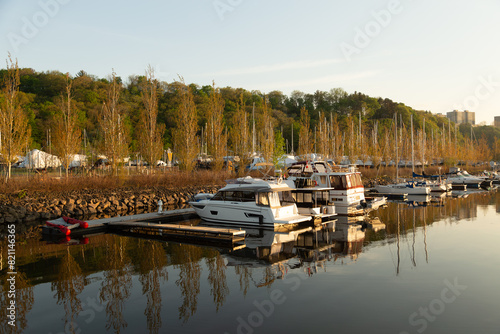 Row of small motorboats and sailboats moored in the Sillery marina during a golden hour spring morning, Quebec City, Quebec, Canada