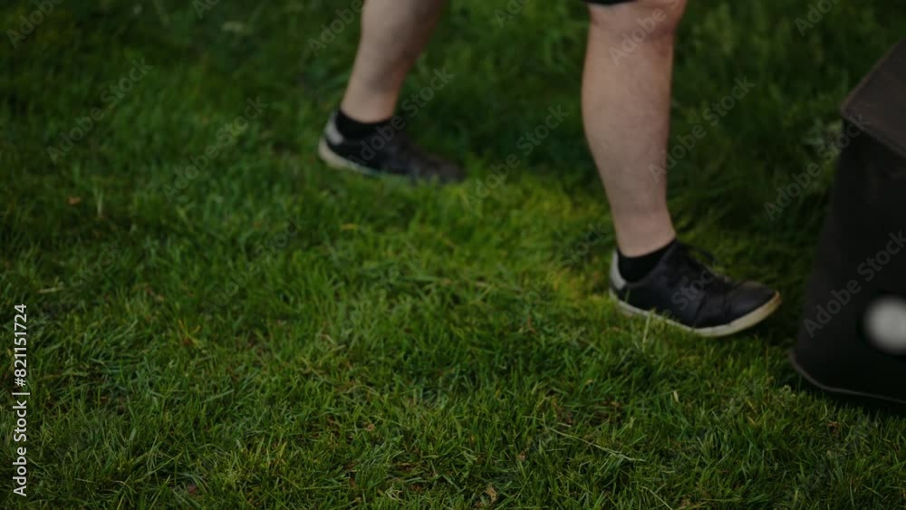 Close-up of a person mowing the lawn with an orange lawn mower, emphasizing garden maintenance and outdoor work. Person Mowing Lawn with Orange Lawn Mower in a Green Garden Scene Close-up of a person mowing the lawn with an orange lawn mower, emphasizing garden maintenance and outdoor work. Person Mowing Lawn with Orange Lawn Mower in a Green Garden Scene