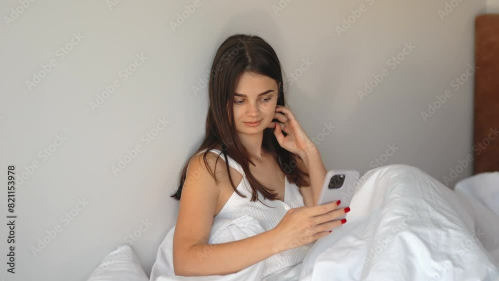 Beautiful girl, model, student without makeup, natural face, holding a phone in her hands and taking a selfie in bed, morning awakening, bed day, phone in her hands, social networks, technology Beautiful girl, model, student without makeup, natural face, holding a phone in her hands and taking a selfie in bed, morning awakening, bed day, phone in her hands, social networks, technology