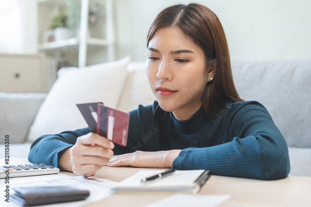 Business financial concept, stressed asian young business woman hand holding credit card for calculate accounting expense of bill, tax for payment on due deadline, trying to find money to pay debt. Business financial concept, stressed asian young business woman hand holding credit card for calculate accounting expense of bill, tax for payment on due deadline, trying to find money to pay debt.