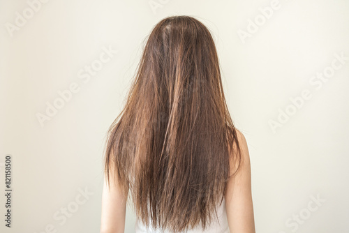 Damaged hair, frustrated asian young woman, girl in splitting ends, messy unbrushed dry hair and frizzy with long disheveled hair, health care of beauty. Portrait isolated on background, Back view.