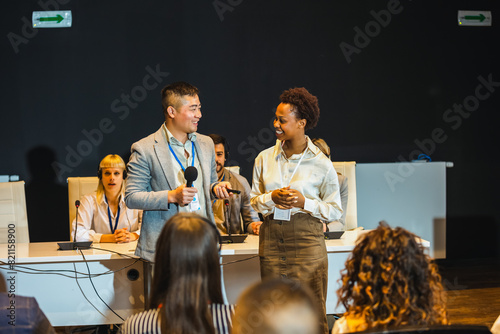 Obraz na plátně Asian and African American business people having speach on a press conference in a convention center