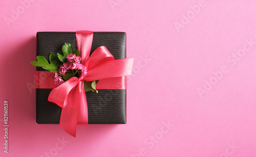 Banner with black craft gift box with empty round tag, hawthorn flowers on pink background. Copyspace