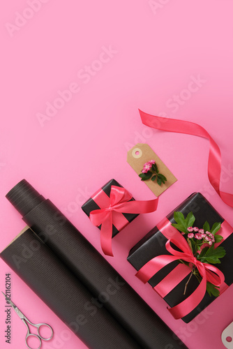 Gift wrapping. Brown craft wrapping paper, pink ribbon, scissors, hawthorn flowers. Copyspace