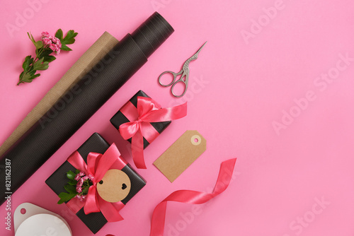 Spring gift wrapping. Brown craft wrapping paper, pink ribbon, scissors, hawthorn flowers. Copyspace