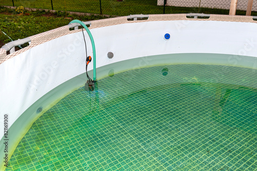 Emptying used water from a garden swimming pool using a home water pump.