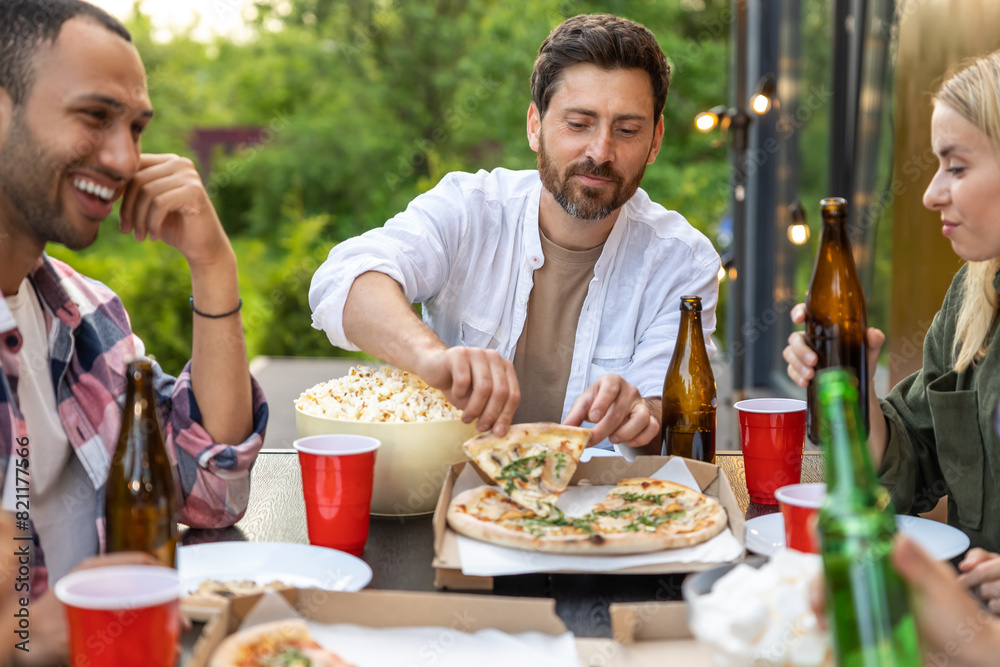 Cheerful friends having picnic outdoor drinking beer enjoying weekend Cheerful friends having picnic outdoor drinking beer enjoying weekend