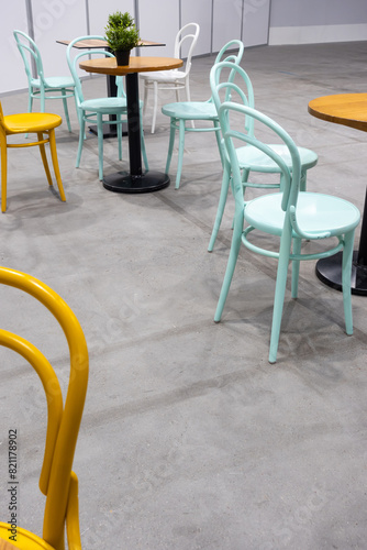 Colorful wooden chairs and tables in a public restaurant. Public places for eating quick meals.
