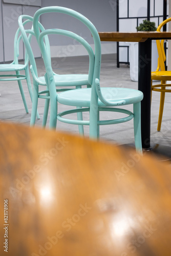 Colorful wooden chairs and tables in a public restaurant. Public places for eating quick meals.