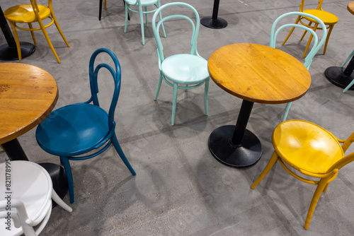 Colorful wooden chairs and tables in a public restaurant. Public places for eating quick meals.