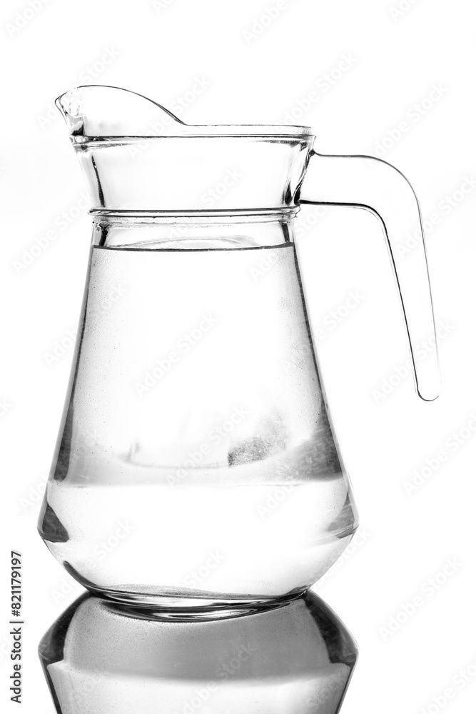 Transparent glass jug with clean water. A pitcher on a white background, photograph taken against the light